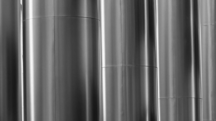 Close-up view of smooth, cylindrical metallic surfaces arranged side by side, representing functional and sustainable materials used in advanced material research.
